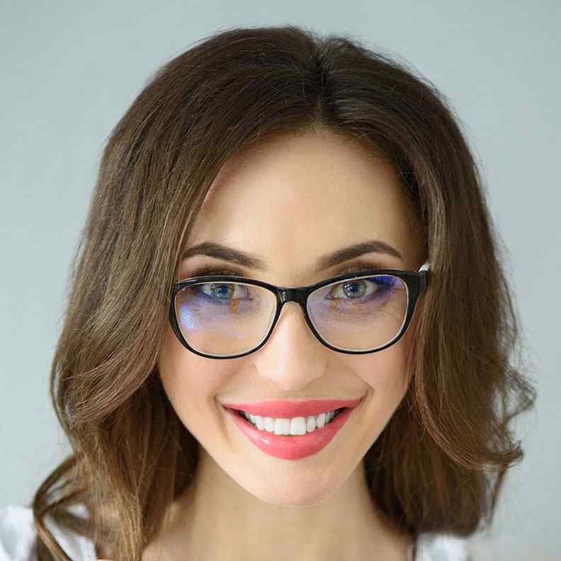 Woman with glasses smiling at the camera.