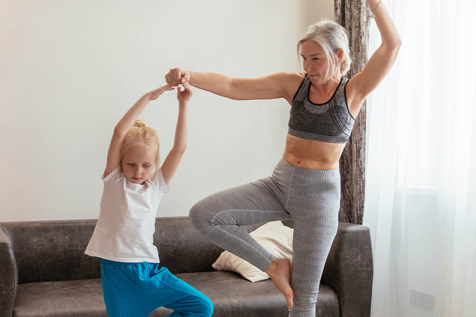 A woman doing yoga with a small child